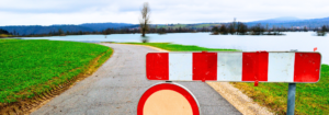 Road closed barrier with a road and lake in the distance